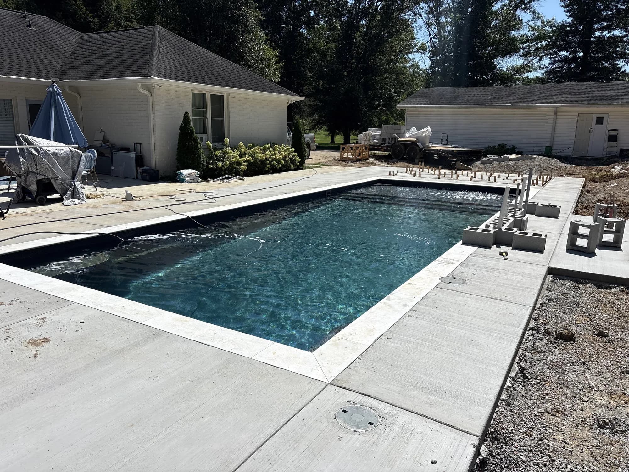 Rectangular pool with dark water surrounded by an active concrete-deck installation